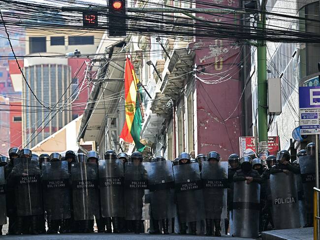 Riot police stand guard during a protest demanding the resignation of Bolivian President Rodrigo Paz, in La Paz, on May 18, 2026. Bolivians have taken to the streets for the past two weeks, blocking roads into La Paz and disrupting deliveries of food, medicine and other goods to the seat of government, while demanding higher wages, economic relief and the resignation of centre-right President Rodrigo Paz amid a severe economic crisis. (Photo by AIZAR RALDES / AFP via Getty Images)
