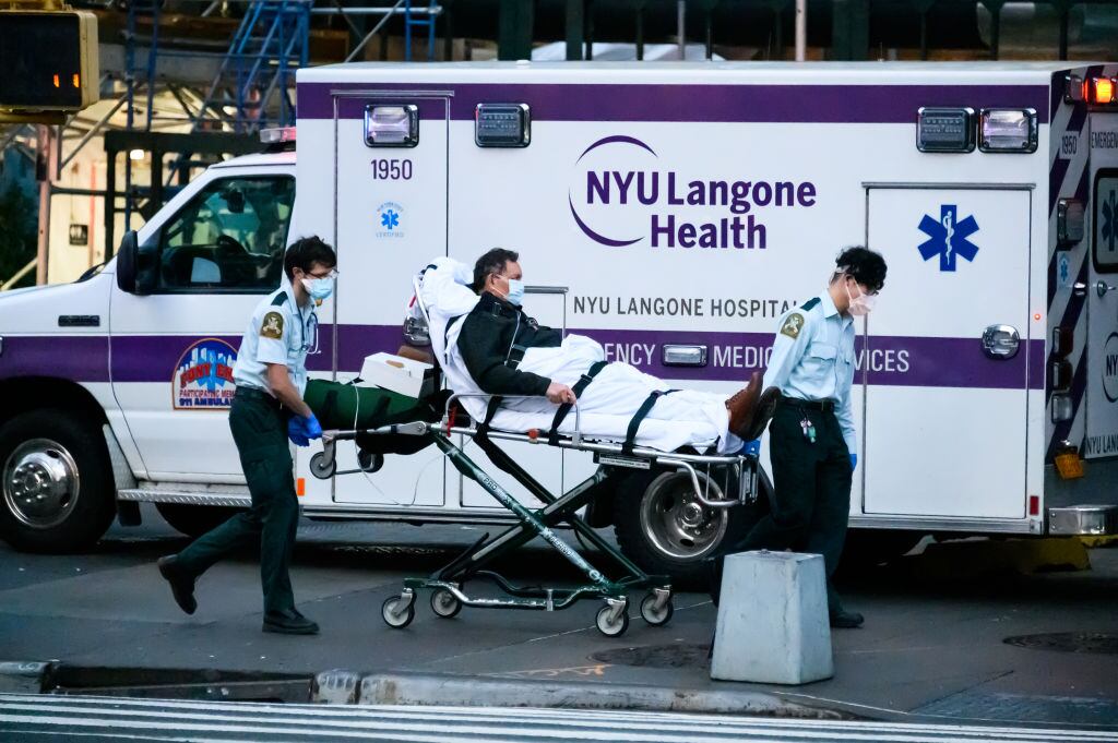 Trabajadores de la salud transportan a un paciente de Covid-19 en Nueva York