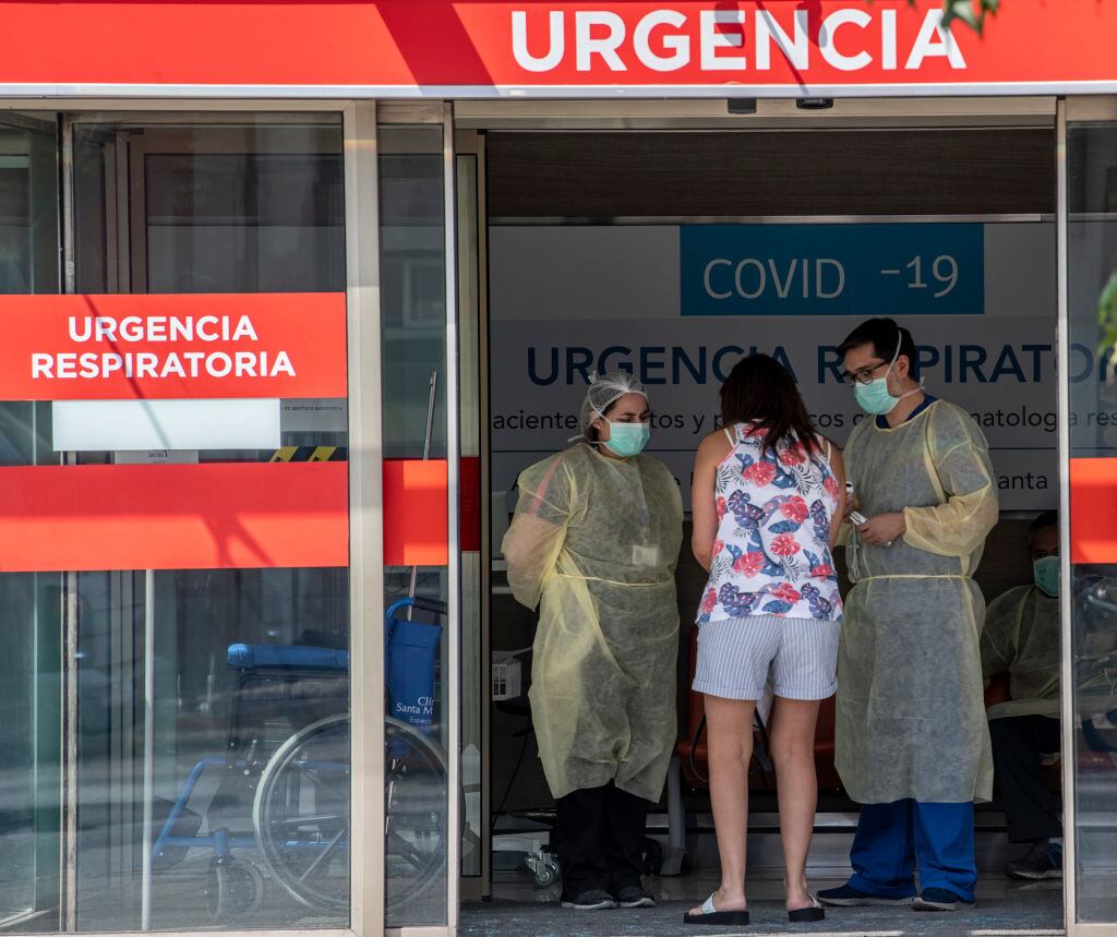 A woman requests information to doctors at the emergency room of a hospital in Santiago, on March 30, 2020. - More than 1.3 million people of seven of the main communes of Santiago were placed into total quarantine aiming to curb the spread of the novel coronavirus, COVID-19. (Photo by Martin BERNETTI / AFP) (Photo by MARTIN BERNETTI/AFP via Getty Images)