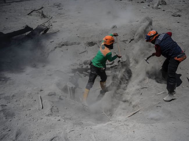 Rescatistas sacan cenizas volcánicas en una villa de la isla de Java