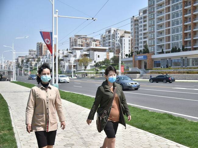 Mujeres con mascarillas caminan en la capital de Corea del Norte
