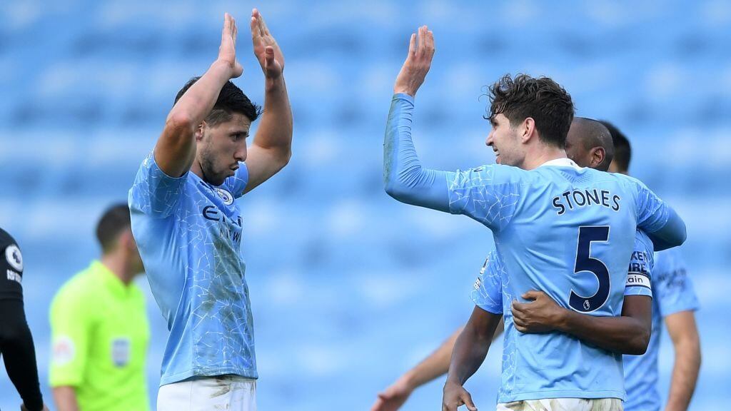 Manchester City's Portuguese defender Ruben Dias (L) celebrates with Manchester City's English defender John Stones after the final whistle during the English Premier League football match between Manchester City and West Ham United at the Etihad Stadium in Manchester, north west England, on February 27, 2021. - Manchester City won the match 2-0. (Photo by Gareth Copley / POOL / AFP) / RESTRICTED TO EDITORIAL USE. No use with unauthorized audio, video, data, fixture lists, club/league logos or 'live' services. Online in-match use limited to 120 images. An additional 40 images may be used in extra time. No video emulation. Social media in-match use limited to 120 images. An additional 40 images may be used in extra time. No use in betting publications, games or single club/league/player publications. / (Photo by GARETH COPLEY/POOL/AFP via Getty Images)