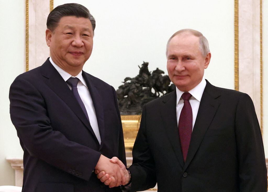 El presidente ruso Vladimir Putin saluda a su par chino Xi Jinping en el Kremlin