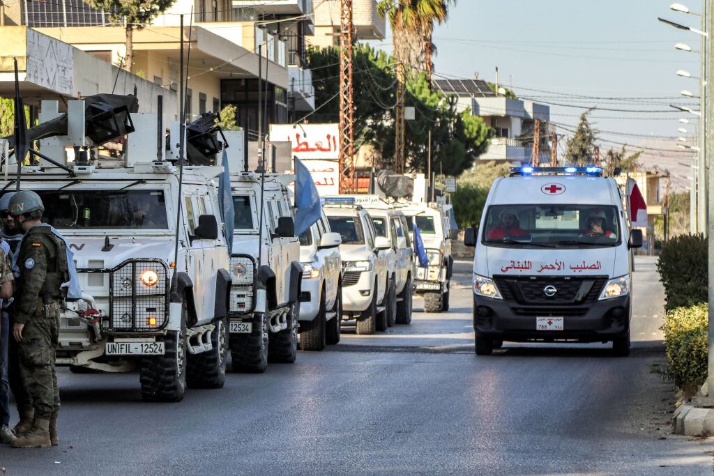Una ambulancia de la Cruz Roja avanza al lado de un convoy de vehículos blindados de los cascos azules de la Unifil en las calles del Líbano