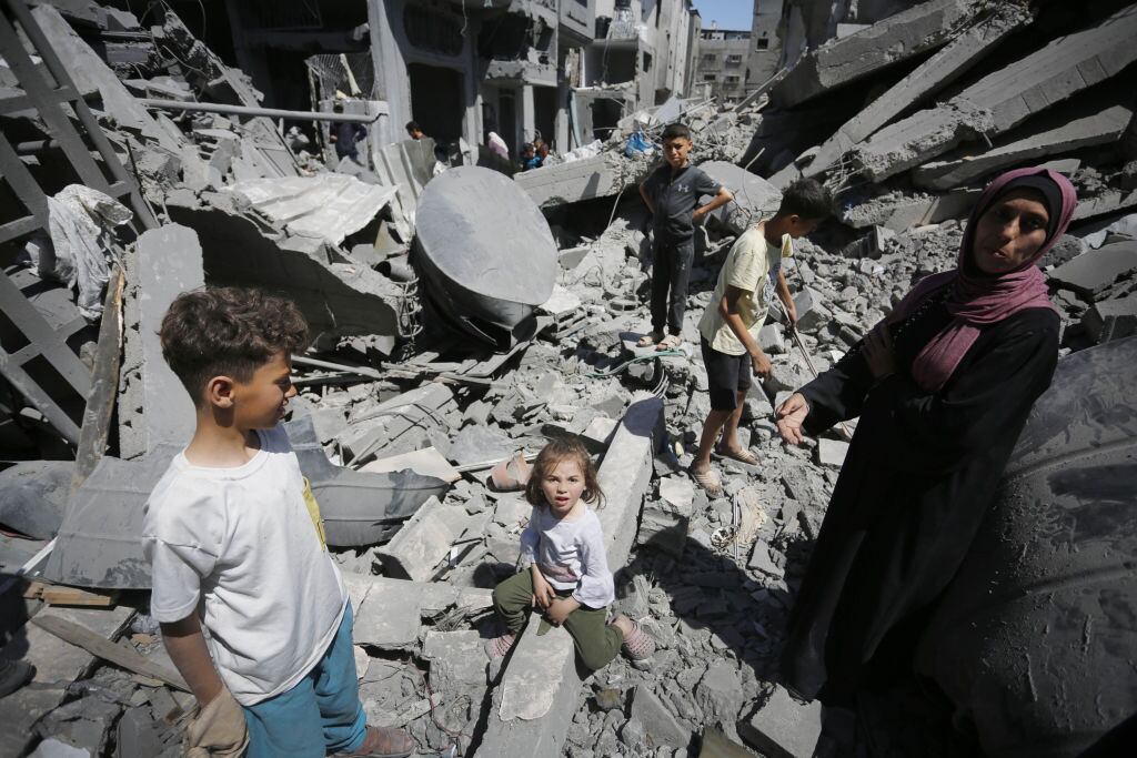 Familia palestina observa la destrucción de viviendas y edificios en la Franja de Gaza que dejan los ataques de Israel.