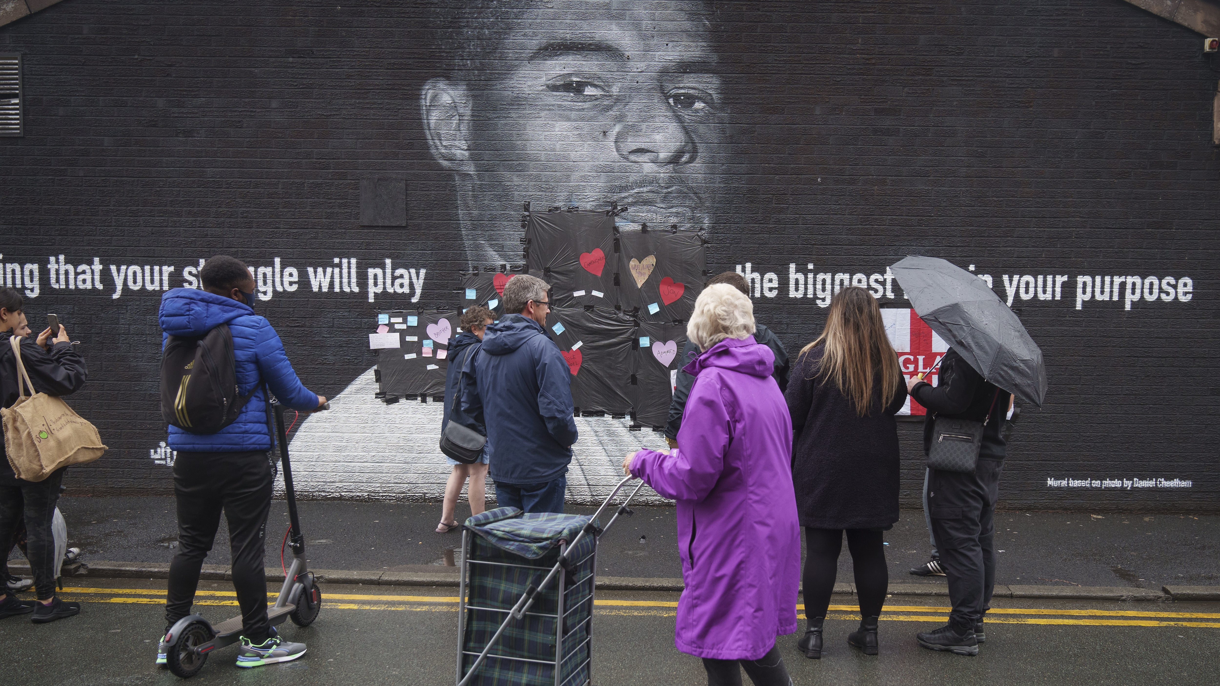 MANCHESTER, ENGLAND - JULY 12: Local residents put messages of support on the plastic that covers offensive graffiti on the vandalised mural of Manchester United striker and England player Marcus Rashford on the wall of a cafe on Copson Street, Withington on July 12, 2021 in Manchester, England. Rashford and other Black players on England's national football team have been the target of racist abuse, largely on social media, after the team's loss to Italy in the UEFA European Football Championship last night. England manager Gareth Southgate, Prime Minister Boris Johnson, and the Football Association have issued statements condemning the abuse. (Photo by Christopher Furlong/Getty Images)