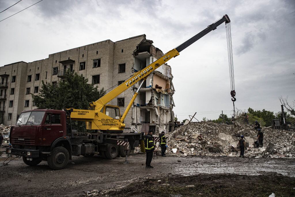 Grúas remueven escombros tras ataque e edificio con misiles en Ucrania
