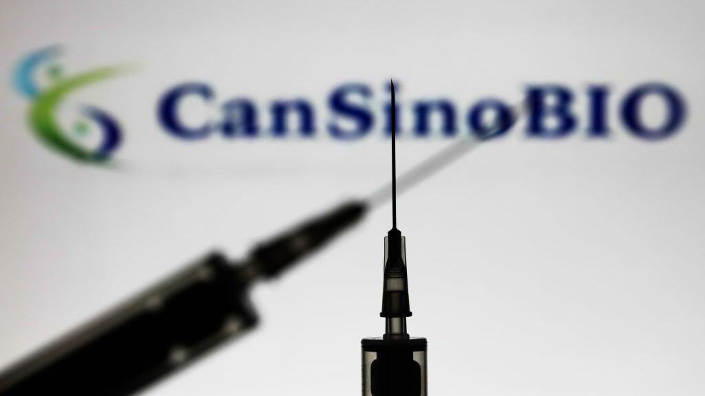 Medical syringes are seen with CanSino Biologics company logo displayed on a screen in the background in this illustration photo taken in Poland on November 15, 2020. (Photo by Jakub Porzycki/NurPhoto via Getty Images)