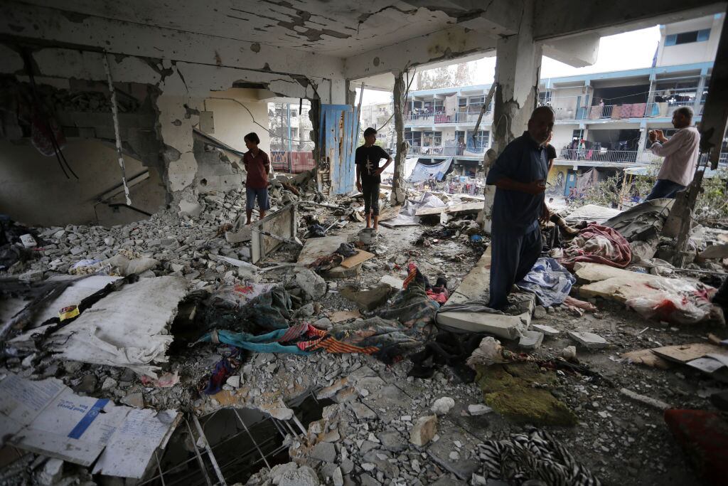 Palestinos buscan entre los escombros en la escuela de la UNRWA en Gaza que fue bombardeada por Israel.