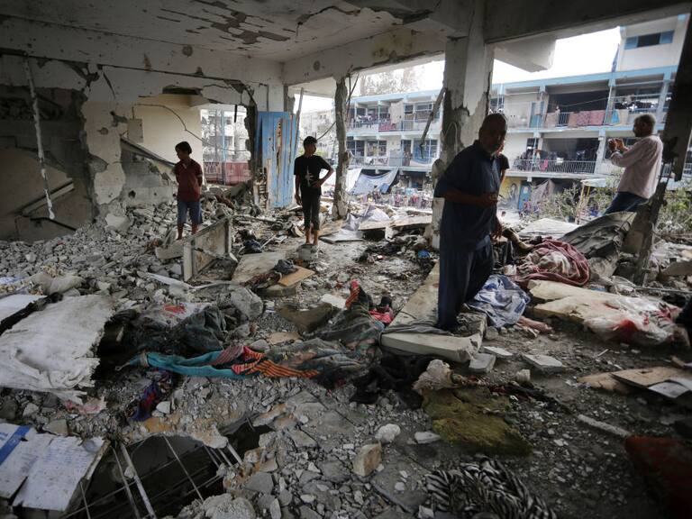 Palestinos buscan entre los escombros en la escuela de la UNRWA en Gaza que fue bombardeada por Israel.