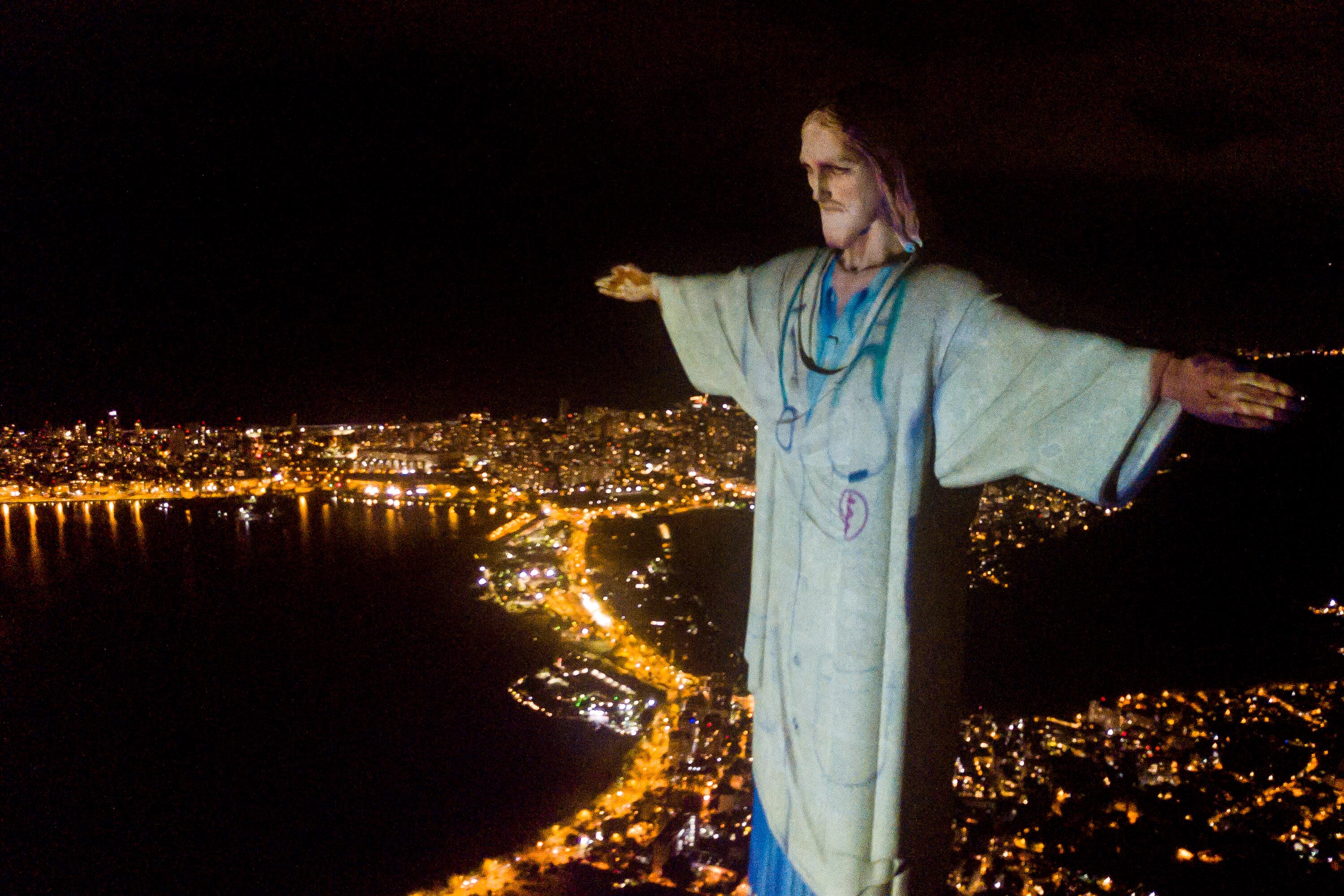 RIO DE JANEIRO, BRAZIL - APRIL 12: Aerial view of the illuminated statue of Christ the Redeemer as Archbishop of the city of Rio de Janeiro Dom Orani Tempesta performs a mass in honor of Act of Consecration of Brazil and tribute to medical workers amidst the Coronavirus (COVID - 19) pandemic on April 12, 2020 in Rio de Janeiro, Brazil. According to the Ministry of health, as today, Brazil has 22,169 confirmed cases of coronavirus (COVID-19) and at least 1223 recorded fatalities. (Photo by Buda Mendes/Getty Images)