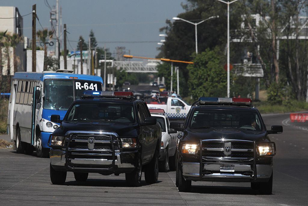 Vehículos de la Policía de México recorren las calles de una ciudad, en medio de la violencia de los bandas criminales.