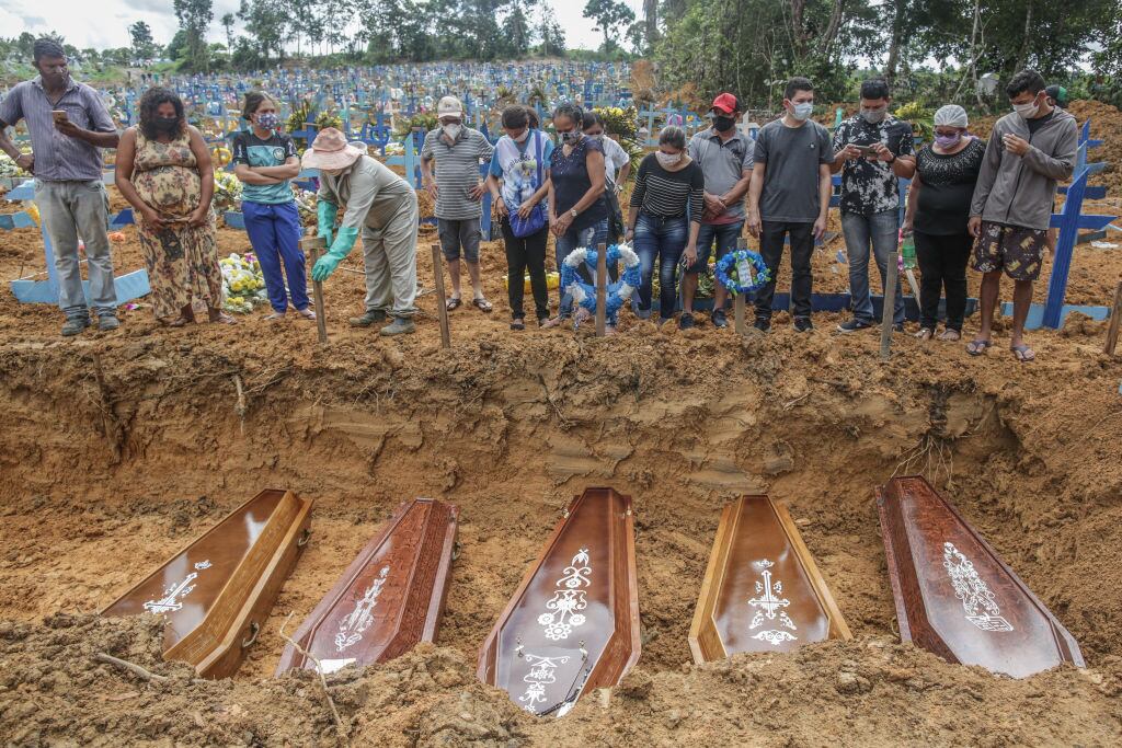 Personas despiden a familiares en entierro masivo por Covid-19 en Brasil