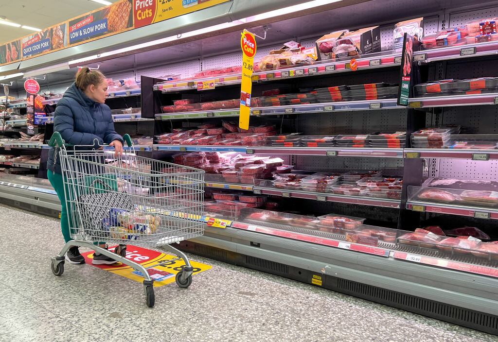 Mujer observa precios para elegir sus compras en mercado del Reino Unido