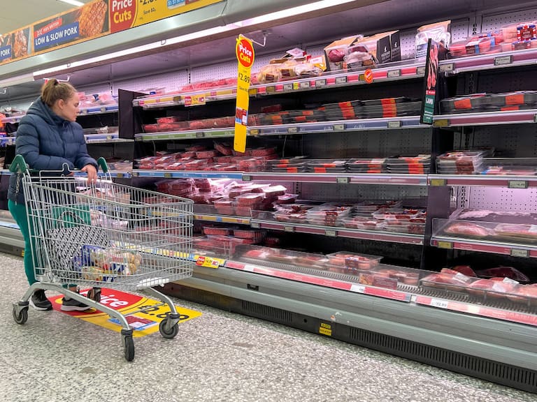 Mujer observa precios para elegir sus compras en mercado del Reino Unido