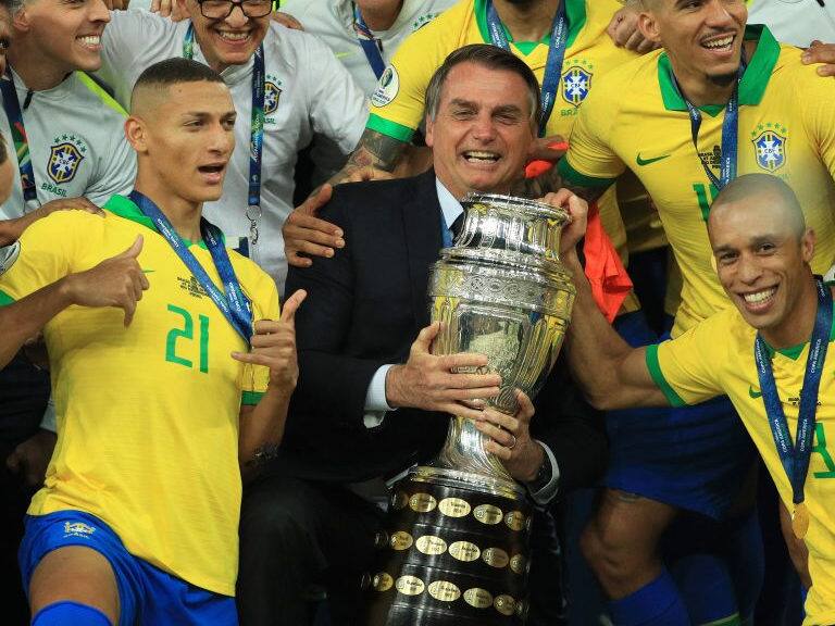 RIO DE JANEIRO, BRAZIL - JULY 07: President of Brazil Jair Bolsonaro celebrates with the trophy and the players of Brazil after winning the Copa America Brazil 2019 Final match between Brazil and Peru at Maracana Stadium on July 07, 2019 in Rio de Janeiro, Brazil. (Photo by Buda Mendes/Getty Images)