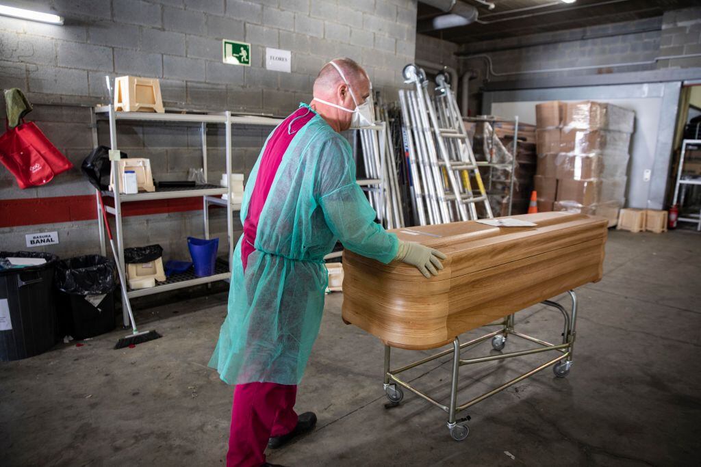 El trabajador de una funeraria conduce un féretro en un crematorio