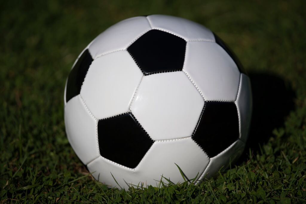 Un balón detenido en una cancha de fútbol