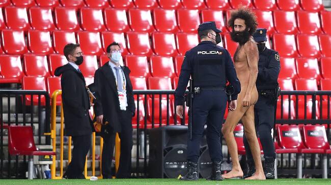 GRANADA, SPAIN - APRIL 08: A streaker is removed from the pitch by Police Officers during the UEFA Europa League Quarter Final First Leg match between Granada CF and Manchester United at Nuevo Estadio de Los Carmenes on April 08, 2021 in Granada, Spain. Sporting stadiums around Europe remain under strict restrictions due to the Coronavirus Pandemic as Government social distancing laws prohibit fans inside venues resulting in games being played behind closed doors. (Photo by Fran Santiago/Getty Images)