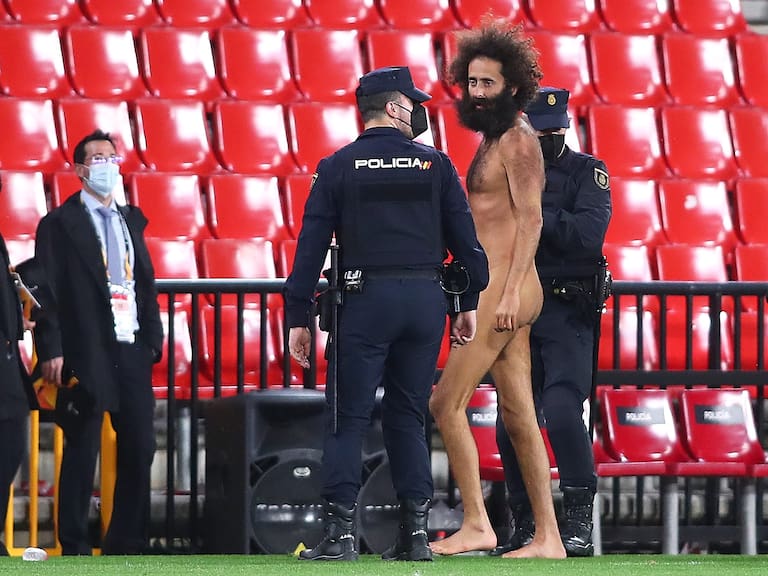GRANADA, SPAIN - APRIL 08: A streaker is removed from the pitch by Police Officers during the UEFA Europa League Quarter Final First Leg match between Granada CF and Manchester United at Nuevo Estadio de Los Carmenes on April 08, 2021 in Granada, Spain. Sporting stadiums around Europe remain under strict restrictions due to the Coronavirus Pandemic as Government social distancing laws prohibit fans inside venues resulting in games being played behind closed doors. (Photo by Fran Santiago/Getty Images)