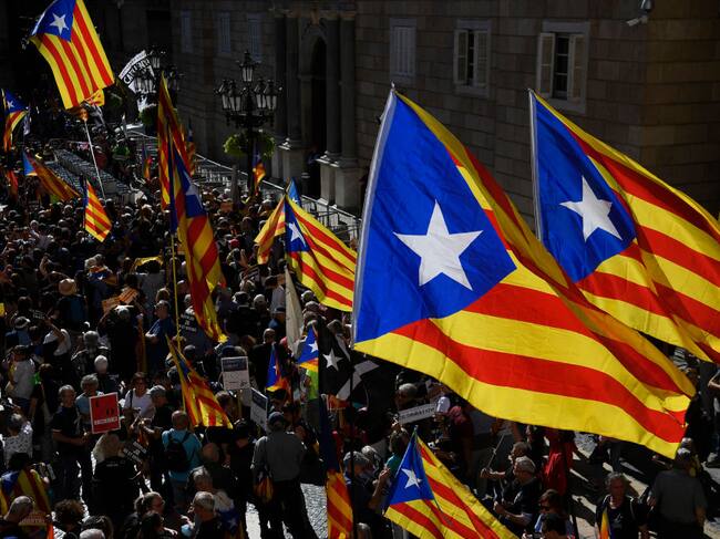 People holding Catalan pro-independence Estelada flags gather at Plaza Sant Jaume in Barcelona on October 1, 2022 to take part in a demonstration marking the fifth anniversary of a self-determination referendum organised by separatists despite being banned by the courts. - Five years after the banned referendum on independence, Catalan separatists appear to be even further from their goal of separating from Spain, with many feeling bitterly let down by their leaders. (Photo by Josep LAGO / AFP) (Photo by JOSEP LAGO/AFP via Getty Images)