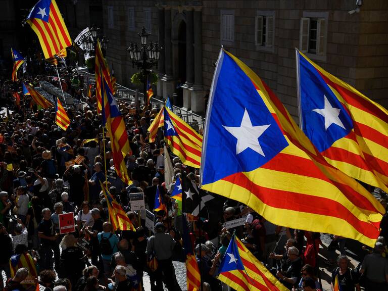 People holding Catalan pro-independence Estelada flags gather at Plaza Sant Jaume in Barcelona on October 1, 2022 to take part in a demonstration marking the fifth anniversary of a self-determination referendum organised by separatists despite being banned by the courts. - Five years after the banned referendum on independence, Catalan separatists appear to be even further from their goal of separating from Spain, with many feeling bitterly let down by their leaders. (Photo by Josep LAGO / AFP) (Photo by JOSEP LAGO/AFP via Getty Images)