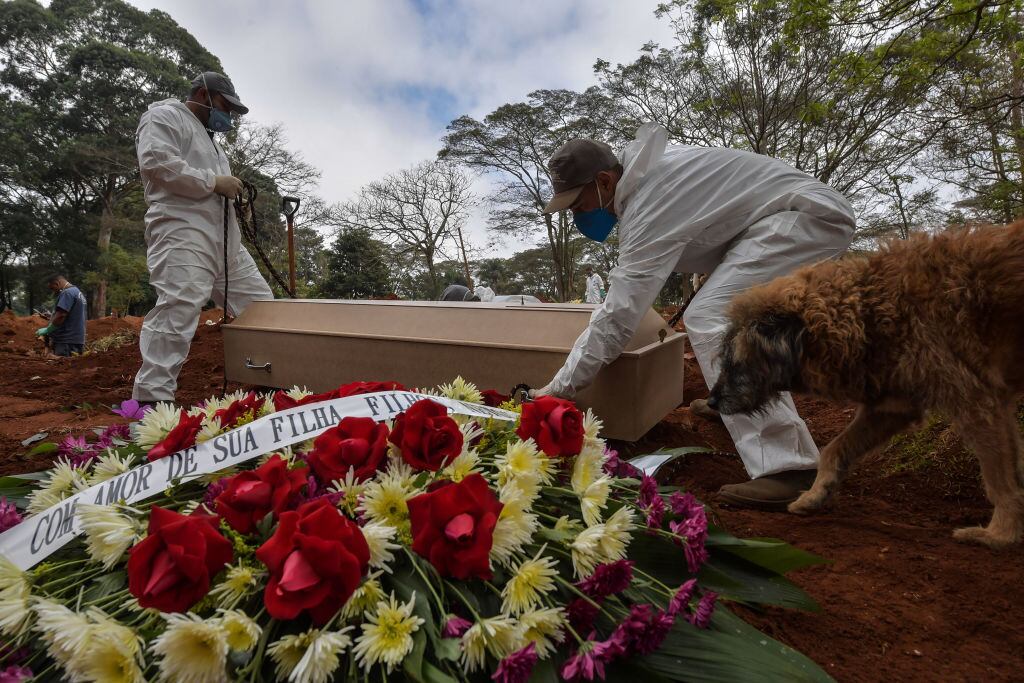 Trabajadores de un cementerio entierran a una víctima del Covid-19 en Brasil