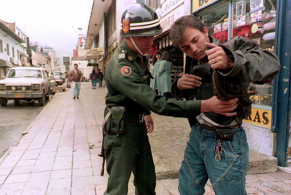 Soldado de Colombia revisa a una personas en la calle durante 1994
