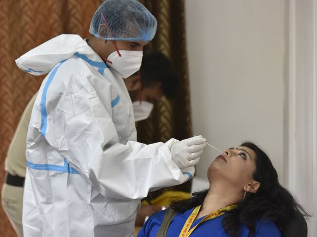 Trabajador de la salud toma un examen PCR en Nueva Delhi