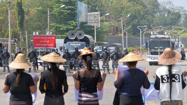 Policías se preparan a reprimir a unas mujeres en Myanmar