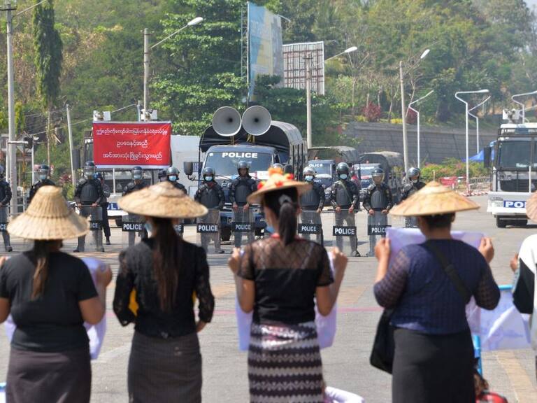 Policías se preparan a reprimir a unas mujeres en Myanmar