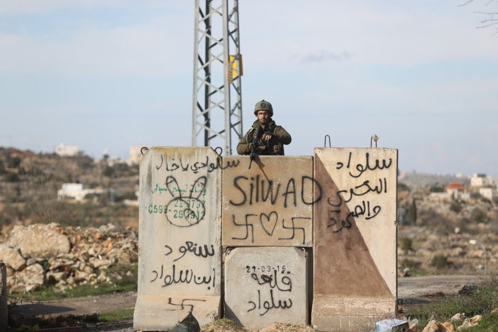Soldado de Israel armado vigila la ciudad ocupada de Ramallah en Palestina
