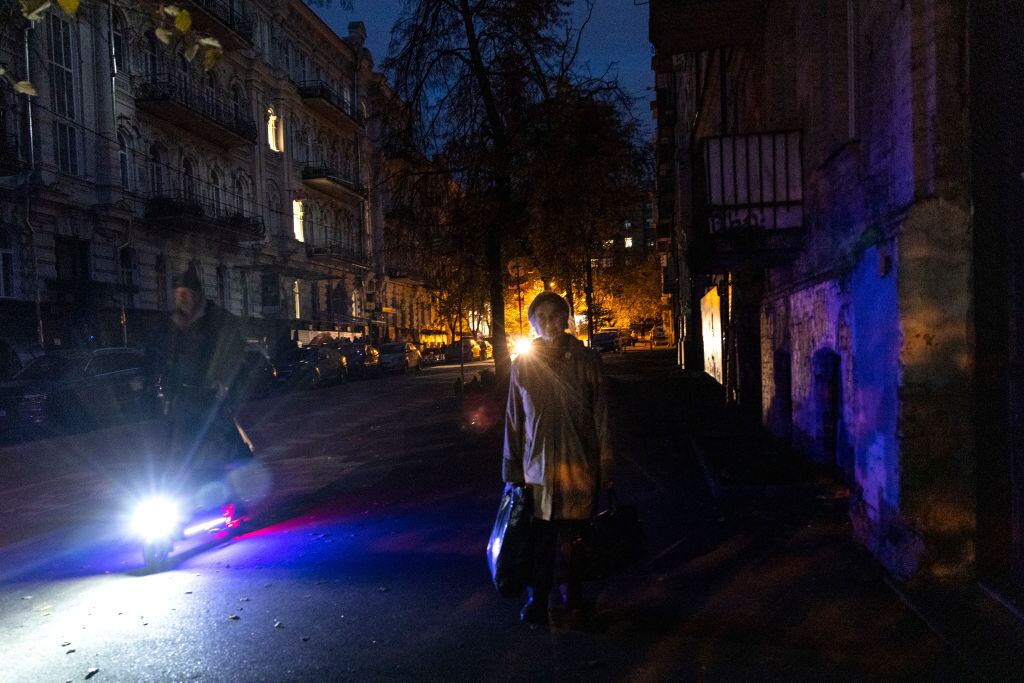 Personas avanzan por las calles sin luz de la ciudad de Kiev en Ucrania