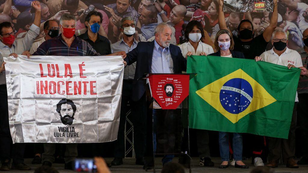 SAO BERNARDO DO CAMPO, BRAZIL - MARCH 10: Luiz Inacio Lula da Silva (C), Brazil's former president, poses for a photo next to Wagner Firmino de Santana (L), President of the metalworkers union and Gleisi Hoffmann (R), National President of the Workers' Party holding flags during a press conference after convictions against him were annulled at the Sindicato dos Metalurgicos do ABC on March 10, 2021 in Sao Bernardo do Campo, Brazil. Minister Edson Fachin, of the Federal Supreme Court, annulled on Monday the criminal convictions against former leftist President Luiz Inacio Lula da Silva on the grounds that the city of Curitiba court did not have the authority to try him for corruption charges and he must be retried in federal courts in the capital, Brasilia. The decision means Lula regains his political rights and would be eligible to run for office in 2022. (Photo by Alexandre Schneider/Getty Images)