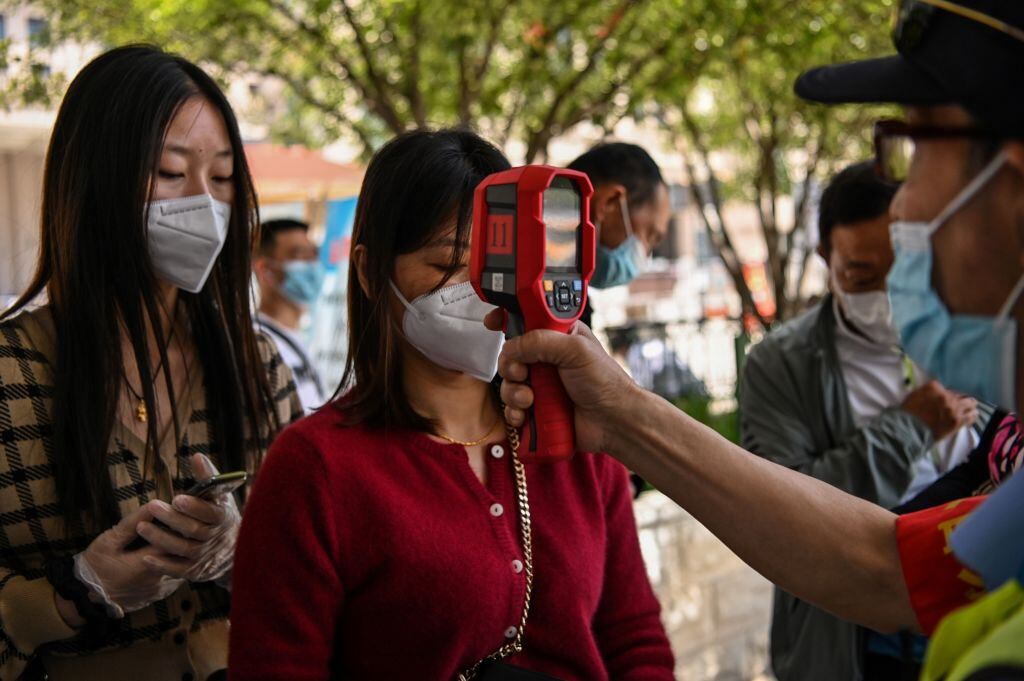 Trabajadores toman la temperatura a personas en China