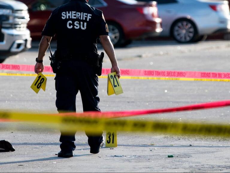 A police officer investigates a crime scene where two people were killed and three more critically injured in a shooting at a flea market in Houston, Texas on May 15, 2022. - Two people were killed and three more were taken to a hospital with injuries after a shooting May 15, 2022 at a bustling Houston flea market, authorities said. The shooting at the open-air market arose from an "altercation" that involved at least two guns and all five of the people, according to Harris County Sheriff Ed Gonzalez. He said no "innocent bystanders" were injured. (Photo by Mark Felix / AFP) (Photo by MARK FELIX/AFP /AFP via Getty Images)