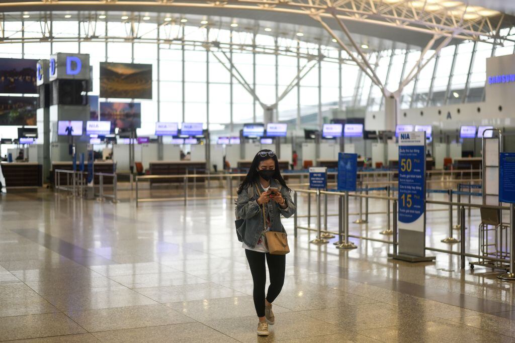 Una pasajera camina al interior de un vacío Aeropuerto Internacional de Hanoi