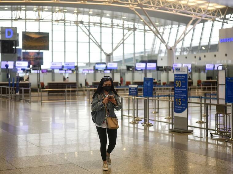 Una pasajera camina al interior de un vacío Aeropuerto Internacional de Hanoi