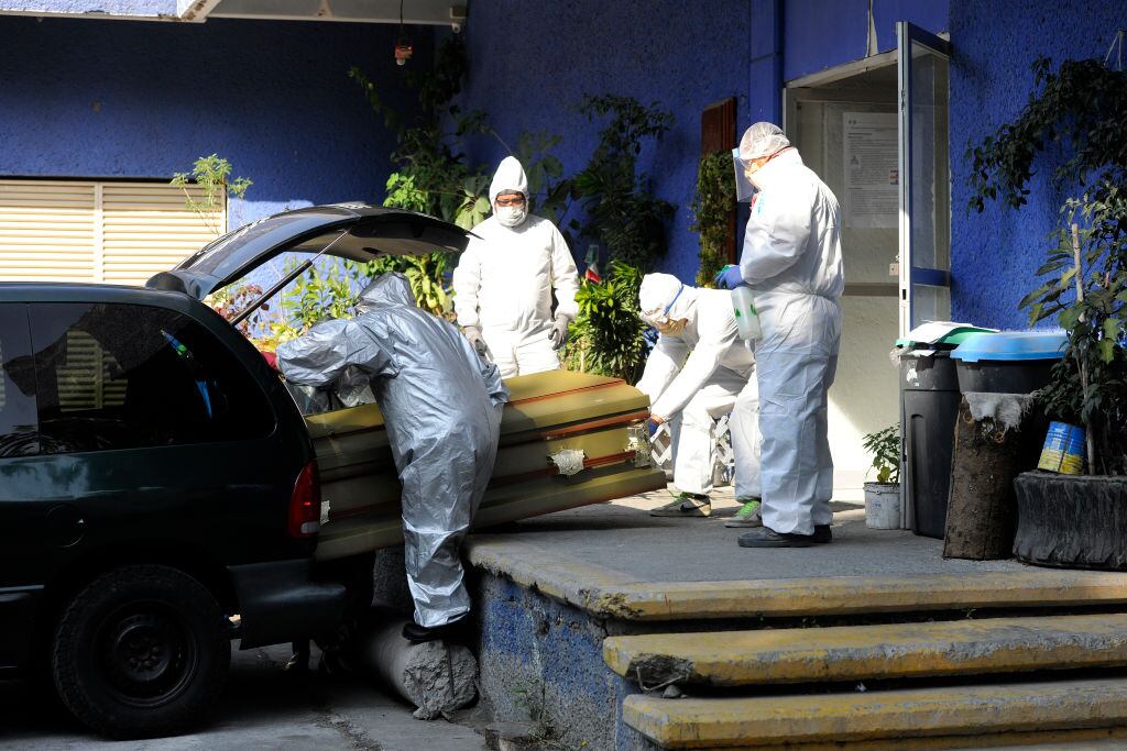 Trabajadores de funeraria trasladan un ataúd en Ciudad de México