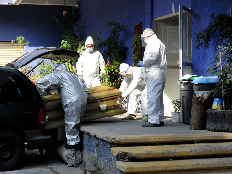 Trabajadores de funeraria trasladan un ataúd en Ciudad de México