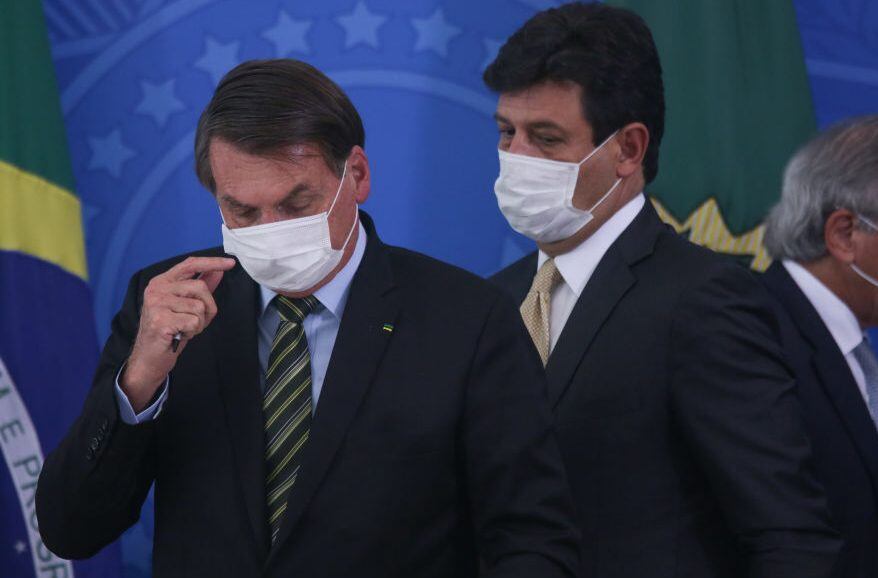 BRASILIA, BRAZIL - MARCH 18: (L-R) President of Brazil Jair Bolsonaro, Health Minister Luiz Henrique Mandetta and Economy minister Paulo Guedes wear protective masks during a press conference regarding government plans and measures about the Coronavirus (COVID-19) Outbreak in Brazil, at the Planalto Palace on March 18, 2020 in Brasilia, Brazil. (Photo by Andre Coelho/Getty Images)