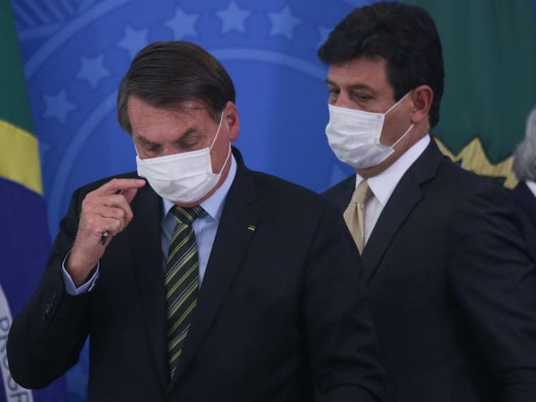 BRASILIA, BRAZIL - MARCH 18: (L-R) President of Brazil Jair Bolsonaro, Health Minister Luiz Henrique Mandetta and Economy minister Paulo Guedes wear protective masks during a press conference regarding government plans and measures about the Coronavirus (COVID-19) Outbreak in Brazil, at the Planalto Palace on March 18, 2020 in Brasilia, Brazil. (Photo by Andre Coelho/Getty Images)