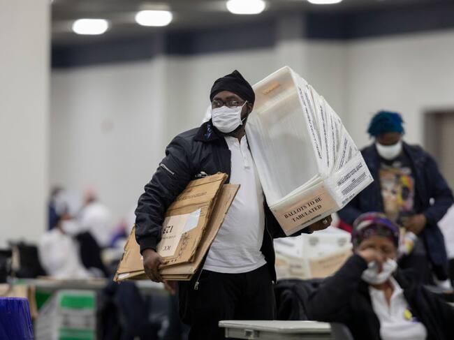 Un trabajador electoral transporta cajas con sufragios en Detroit