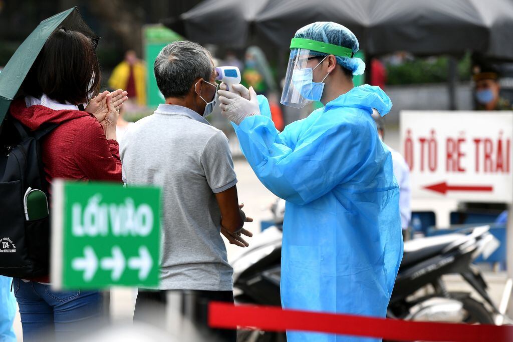 Personal sanitario toma la temperatura a ciudadanos de Vietnam