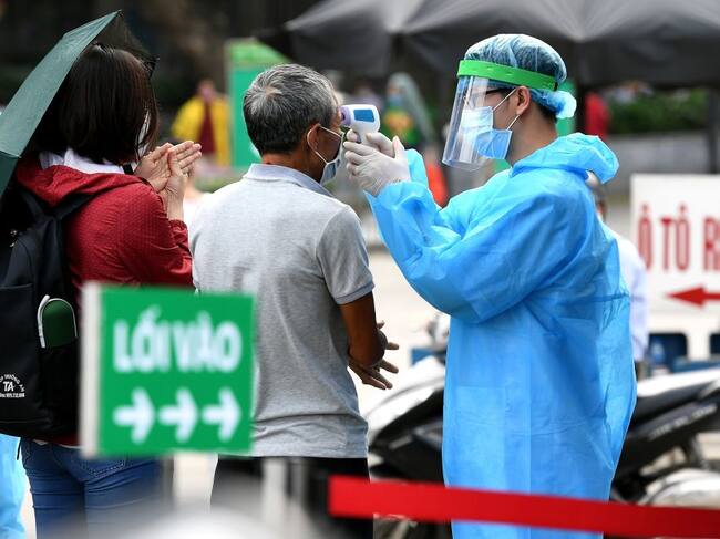 Personal sanitario toma la temperatura a ciudadanos de Vietnam
