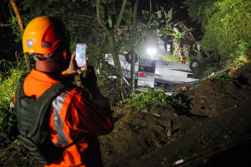 Rescatistas evacúan pasajeros del bus volcado en Indonesia