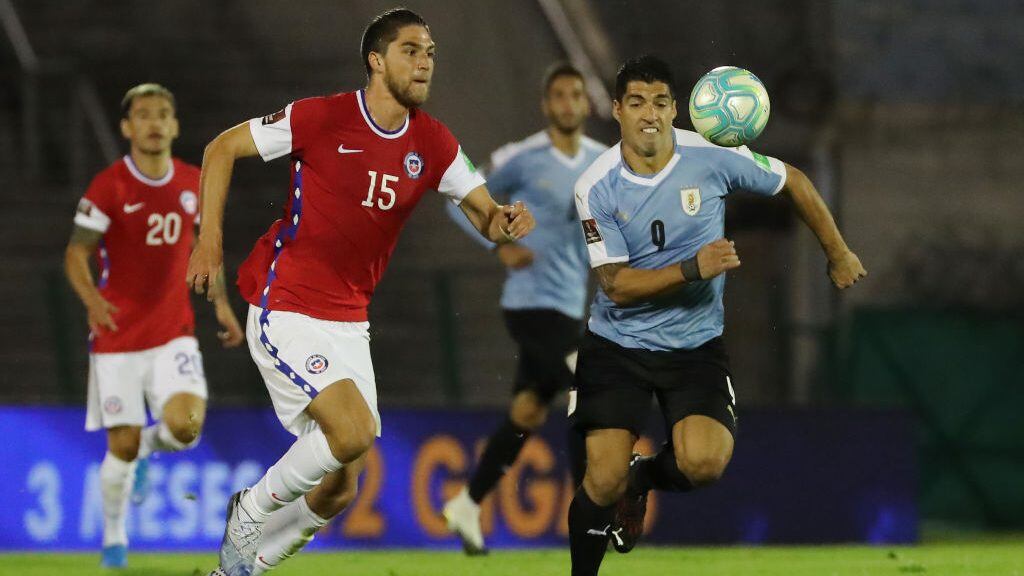 MONTEVIDEO, URUGUAY - OCTOBER 08: Luis Suarez of Uruguay fights for the ball with Francisco Sierralta of Chile during a match between Uruguay and Chile as part of South American Qualifiers for Qatar 2022 at Centenario Stadium on October 08, 2020 in Montevideo, Uruguay. (Photo by Raul Martinez -Pool/Getty Images)