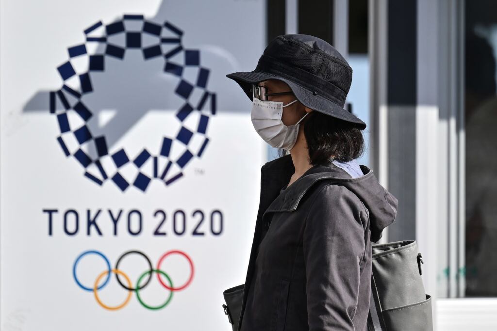 Una mujer camina ante del logo de los JJOO de Tokio