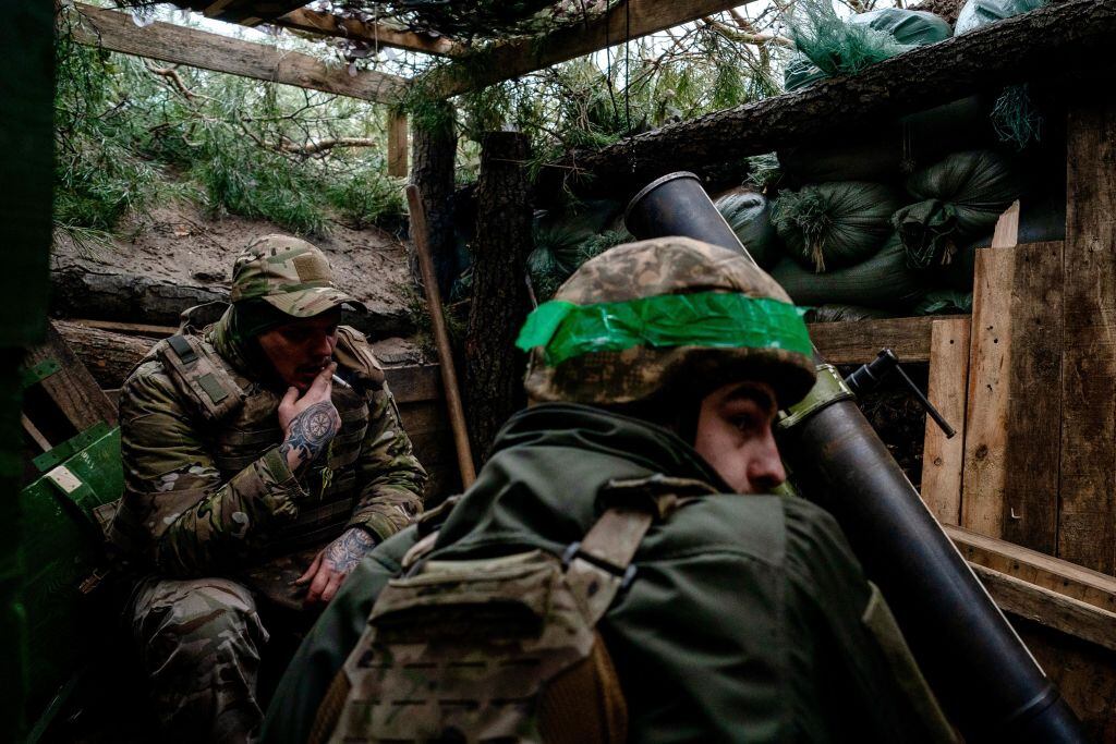 Dos soldados del Ejército de Ucrania se protegen al interior de una trinchera en la región de Donetsk.