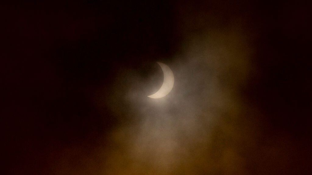 The moon partially covers the sun during a total solar eclipse as seen from Pucon, southern Chile, on December 14, 2020. - The hopes of thousands of tourists and residents in Chile's south saw their hopes of watching a total eclipse of the sun shrink as heavy rain fell on Monday just hours before the expected event. (Photo by Martin BERNETTI / AFP) (Photo by MARTIN BERNETTI/AFP via Getty Images)